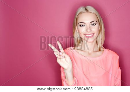 Smiling blond-haired woman pointing with fingers