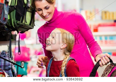 Family buying school satchel or bag in store preparing for first day in school