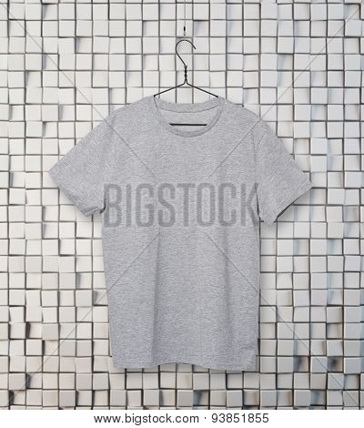 Close-up Of The Grey T-shirt On The Clothes Hanger. Mosaic Background.