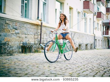 Joyful girl on bicycle having fun