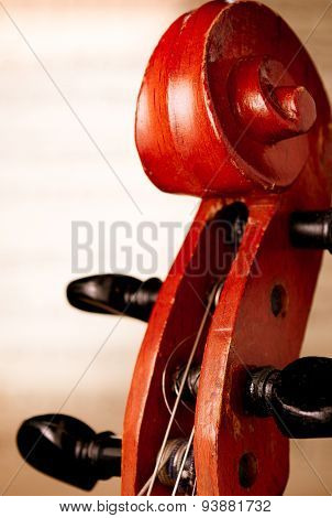 Close Up Of Violin Scroll In Front Of Sheet Music