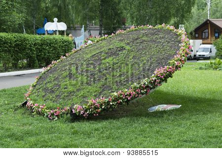 Topiary Figure On The Grass Lawn In The Park - A Sundial In The Form Of Inclined Wheel, One Hand Rai