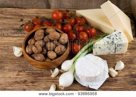 Three Kinds Of Cheese And Various Vegetable On Wooden Board