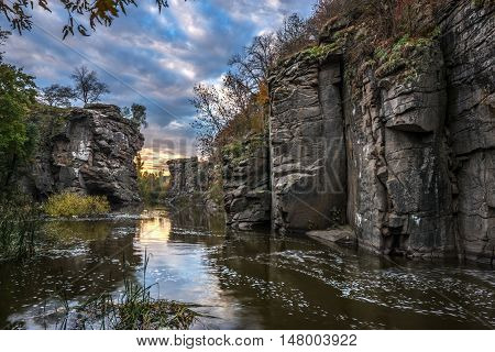 Buky Canyon (River Hirs'kyi Tikych - Ukraine) in autumn season. Beautiful clouds reflect in water.