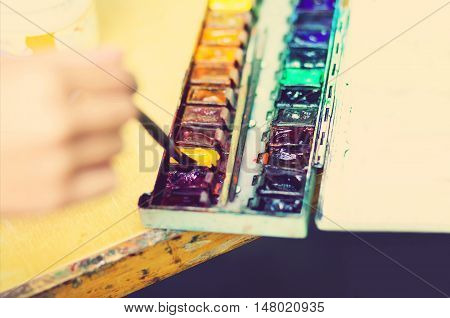 Paintbrush artist drawing watercolor picture dunks brush and painting