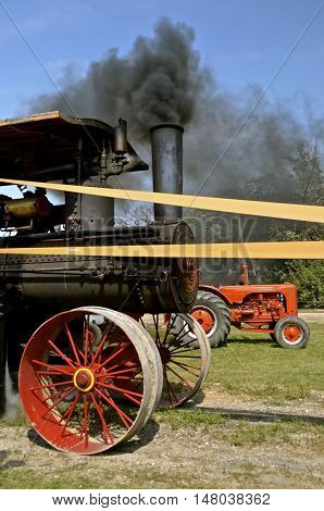 ROLLAG, MINNESOTA, Sept 1. 2016: A smoke blowing steam engine with an old Case tractor are displayed at the West Central Steam Threshers Reunion in Rollag, MN attended by 1000's held annually on Labor Day weekend.