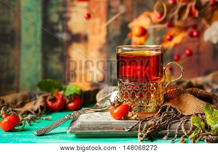 Glass of rose hip tea in a silver glass-holder and fresh berries
