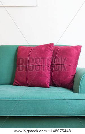 Green sofa and red backrest pillow in living room