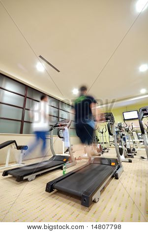 Hombre corriendo en la cinta de correr en el gimnasio