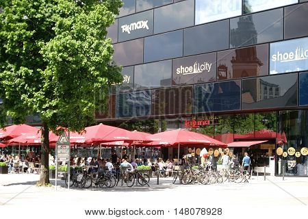 BERLIN, GERMANY - MAY 10: Guests and visitors sit in good weather in the cafe La Luna at Alexander square and eat ice and drink refreshment on May 10 2016 in Berlin.