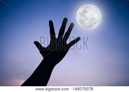 Silhouette Of A Hand With Full Moon On Fantastic Sky Background.