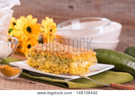 Rice timbale with zucchini on wooden table.