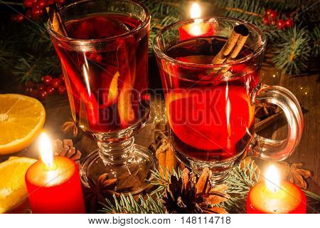 christmas mulled wine with spices and orange in the candle light. festive romantic drinks background