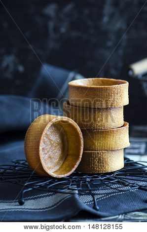 Stack of empty tartlets on dark background