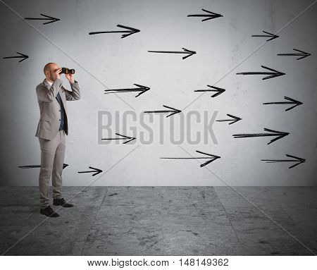 Man looks through binoculars with arrows on the wall