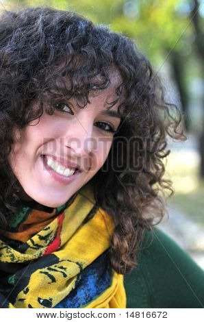 bruneta roztomilá mladá žena s barevný šátek s úsměvem venku v přírodě