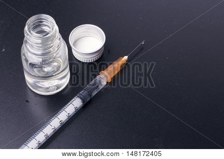 One Syringe And A Mysterious Vial On A Dirty Table.