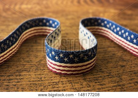 Background for American election or commemorative event. A textile with stars and stripes pattern on old rustic wooden table.   