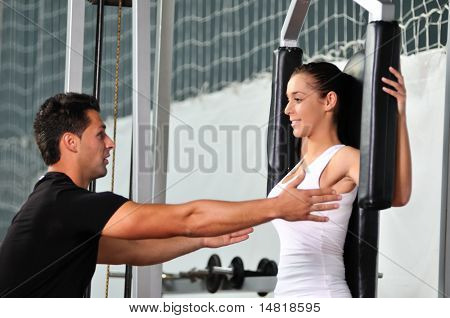 donna nella gim fitness lavorando con allenatore personal trainer