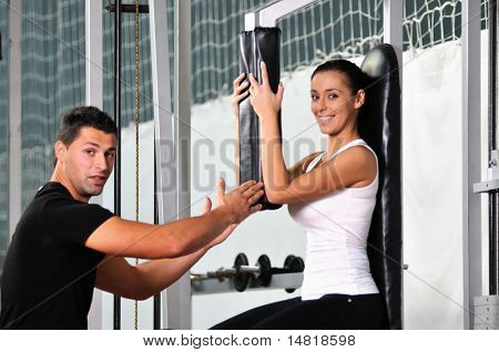 donna nella gim fitness lavorando con allenatore personal trainer