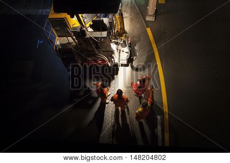 Wallau, Germany - September 16, 2016: High angle view of construction site on German highway A66 at night some workers in the foreground - long exposure