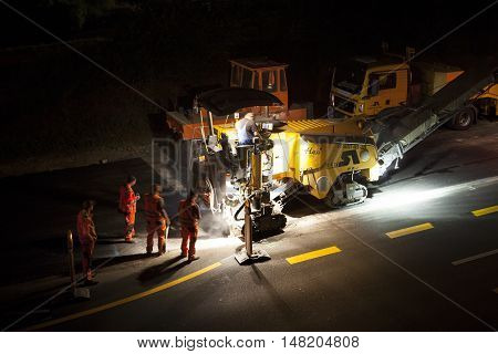Wallau, Germany - September 16, 2016: High angle view of construction site on German highway A66 at night some workers in the foreground - long exposure