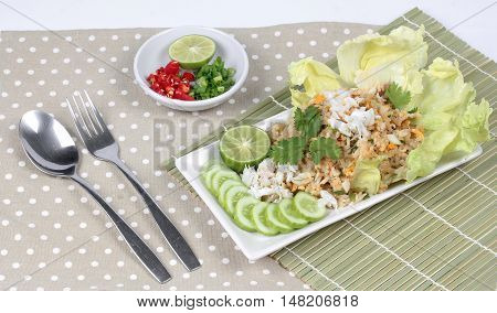 Fried rice with crab topped streamed crab,halve green lemon,sliced cucumber,lettuce and coriander  served  spicy  sour filling side dish. Side view.