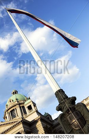 House of the National Assembly of Serbia in Belgrade with serbian flag in the wind