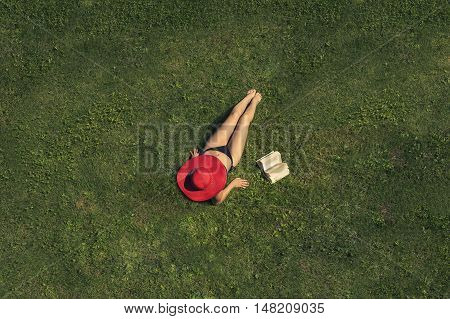 Woman lying on the grass near with book