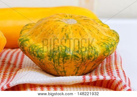 Autumn squash and zucchini on a table cloth.