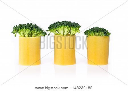 A group of three green broccoli embedded into pasta on a white backround