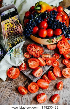 Tomato on wooden table. Freshly Picked red Tomatoes. Variation of tomatoes on wooden surface. Vegetables in the section. Harvesting. Healthy food from the garden.