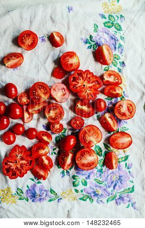 Tomato on wooden table. Freshly Picked red Tomatoes. Variation of tomatoes on wooden surface. Vegetables in the section. Harvesting. Healthy food from the garden.