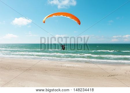 Paragliding on the deserted beach, unspoiled nature
