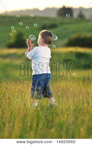 heureux jeune bel enfant Amusez-vous sur pouve avec jouet de bulles de savon
