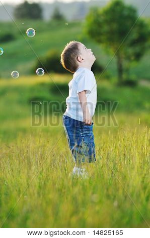heureux jeune bel enfant Amusez-vous sur pouve avec jouet de bulles de savon