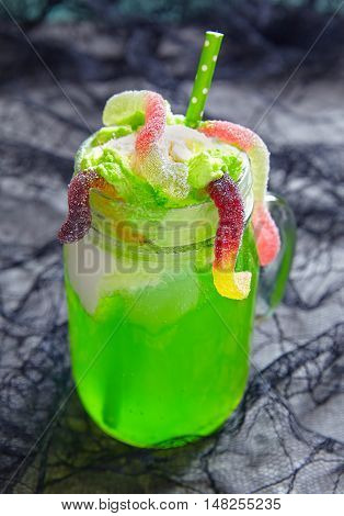 Green drink with ice cream float and jelly worms for Halloween