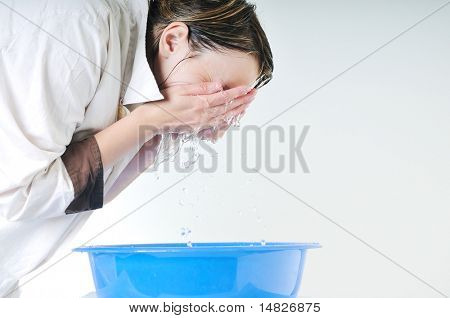 bautiful young woman wash face with clean water isolated on white in studio