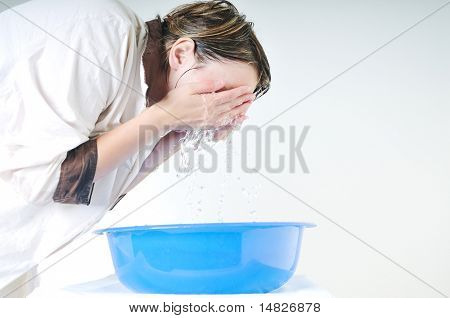 bautiful young woman wash face with clean water isolated on white in studio