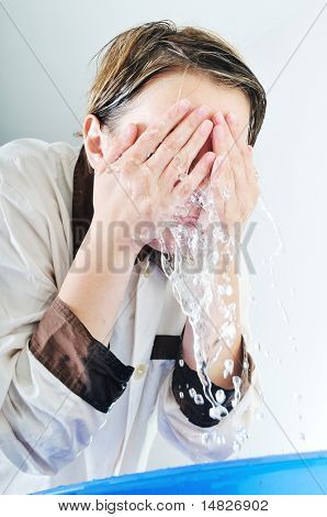 bautiful young woman wash face with clean water isolated on white in studio