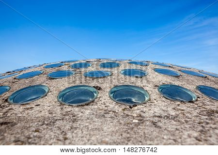 on the roof of a building there is a concrete dome with small glass