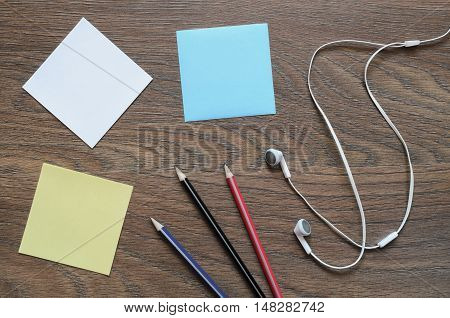 White Headphone, Paper And Pencil On Wooden Table