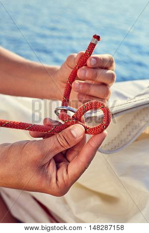 User knitting knots. Bowline knot. Process of tying Bowline process is a top view on the sail.