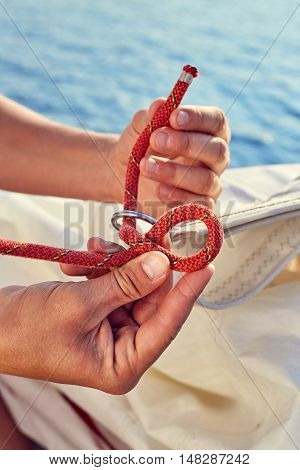 User knitting knots. Bowline knot. Process of tying Bowline process is a top view on the sail.