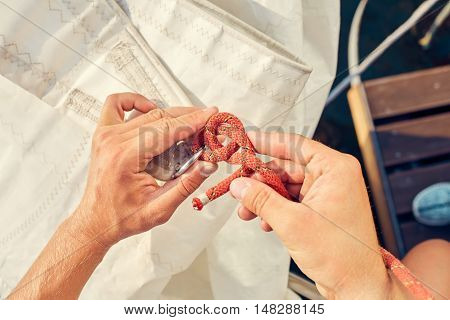 User knitting knots. Bowline knot. Process of tying Bowline process is a top view on the sail.
