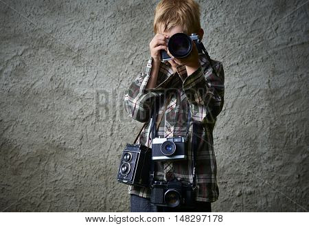 Child boy photographer with many cameras around his neck. Photographer enthusiast