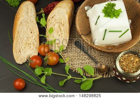 Goat cheese with fresh tomatoes on wooden table. Fresh cheese and pastries. Diet food. Goat cheese with vegetables.