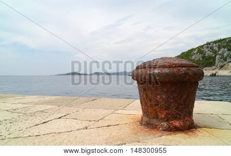 Rusty metal mooring bolard for big ship.