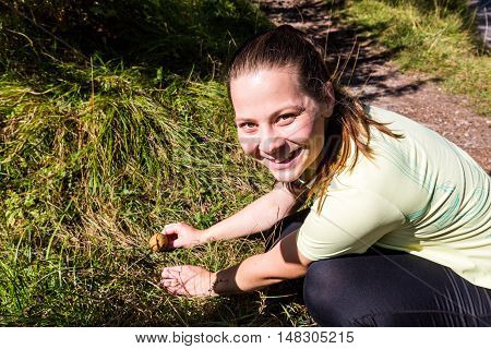 Girl In Sport Clothes Finding A Mushroom In The Forest