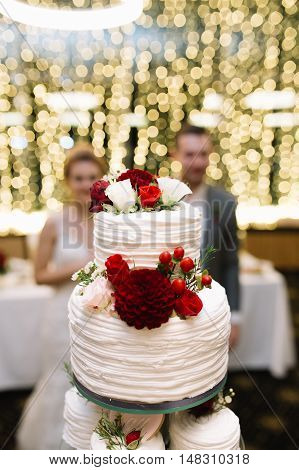 white tiered wedding cake with flowers and berries